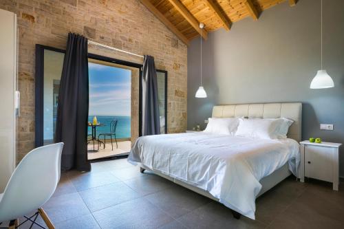 a bedroom with a large bed and a large window at Kaminia Blu in Ratzaklíon