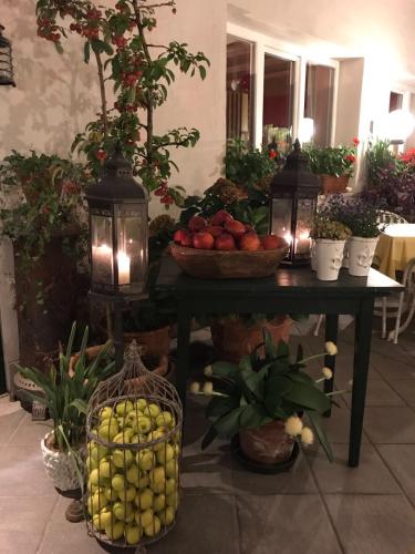 a table with bowls of fruit and lights on it at B&B Pizzeria Zur Traube in Montagna