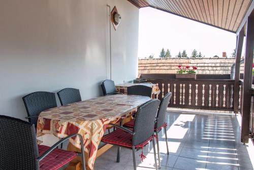 ein Esszimmer mit einem Tisch und Stühlen auf dem Balkon in der Unterkunft Pingvin Cukrászda Apartman felső szint in Balatonmáriafürdő