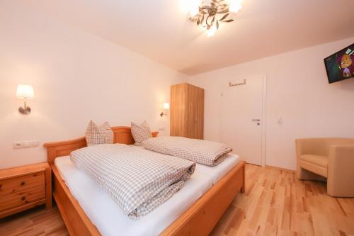 a bedroom with a bed and a chair at Ferienwohnungen Wartbichler in Lofer