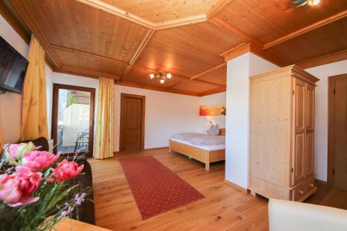 a bedroom with a bed in a room with wooden ceilings at Ferienwohnungen Wartbichler in Lofer