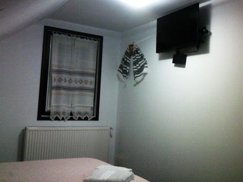a bedroom with a bed and a television on the wall at Casa Lia in Valea Putnei