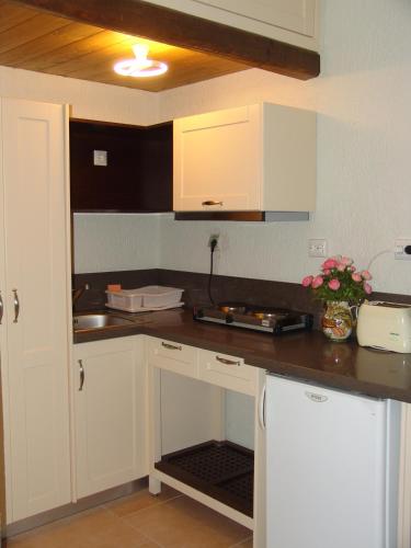 a kitchen with white cabinets and a counter top at Porto Sisi Hotel Apartments in Sissi