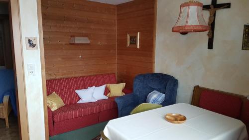 Haus Rochard في Kienzen: غرفة معيشة مع أريكة حمراء وطاولة