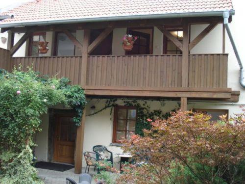 a house with a balcony with chairs and a table at Family in Domažlice