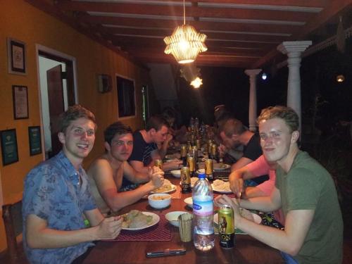 a group of people sitting at a table eating at Plantation Surf Inn & Restaurant - Midigama in Midigama
