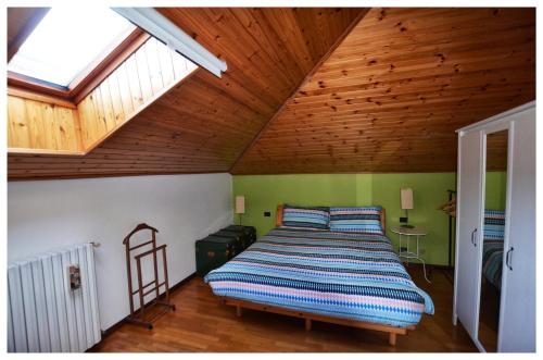 a bed in a room with a wooden ceiling at WAOBAB - We are one B&B in Alzano Lombardo