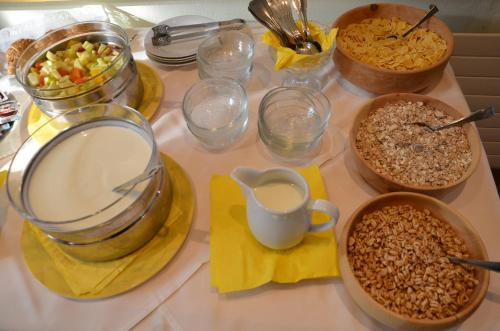a table topped with bowls of cereal and other food at Wellness Landhaus Parth in Ossiach