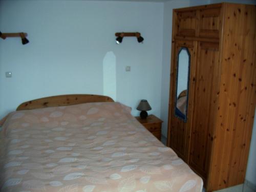 1 dormitorio con 1 cama y armario de madera en Charmante Ferienwohnung, en Plön