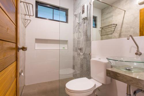 a bathroom with a toilet and a glass shower at Light Khao Lak Resort in Khao Lak