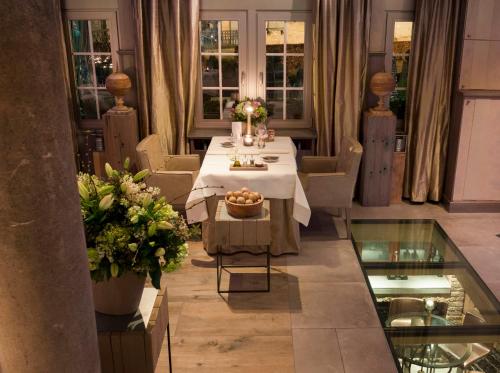 uma sala de jantar com uma mesa com flores em Suite & B by Hofke van Bazel em Bazel
