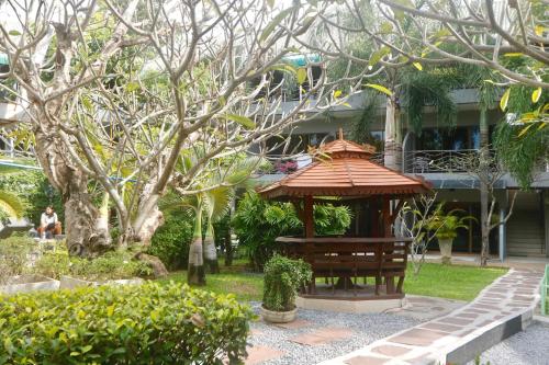 a garden with a gazebo in front of a building at Momento Resort in Pattaya South