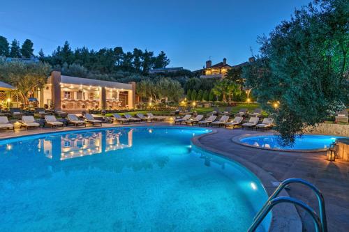 a swimming pool with lounge chairs and a resort at Kassandra Village Resort in Pefkochori