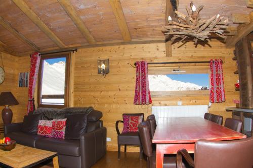 un salon avec une table, des chaises et un canapé dans l'établissement Tignes duplex luxe parking 6-8 p, à Tignes
