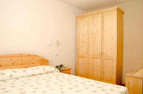 1 dormitorio con 1 cama y armario de madera en Agritur Acquastilla Giovanni Poli, en Arco