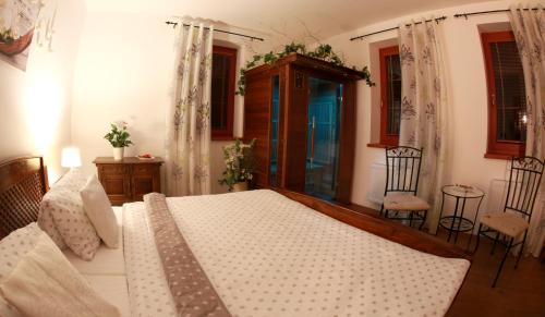 a bedroom with a large bed and two chairs at Penzion Recall in Troskovice