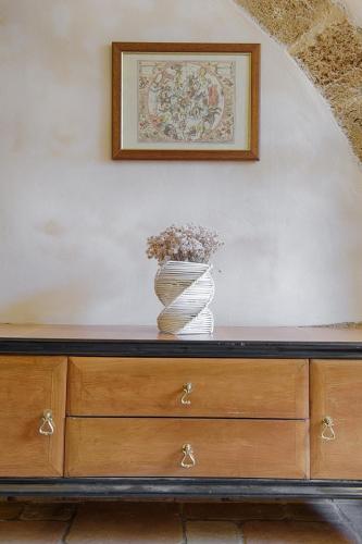 a wooden dresser with a vase on top of it at Sacratum B&B Suite Spa in Mesagne