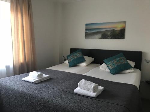 2 Betten in einem Schlafzimmer mit Handtüchern darauf in der Unterkunft Hotel Valkenhof in Zoutelande