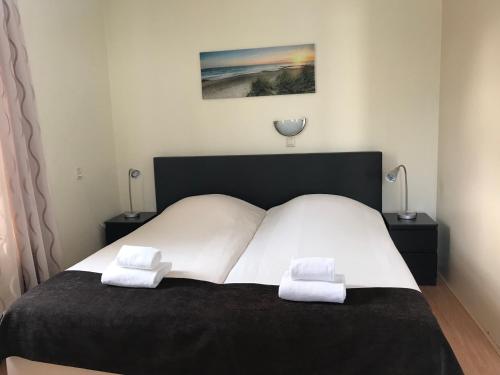 ein Schlafzimmer mit einem Bett mit zwei weißen Handtüchern darauf in der Unterkunft Hotel Valkenhof in Zoutelande