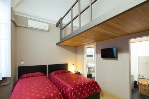 ジェノヴァにあるHelvetia Suiteのベッドルーム1室(赤い掛け布団付きのベッド1台付)