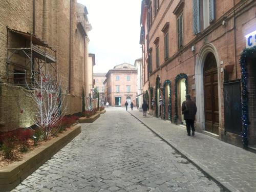 a cobblestone street with people walking down the street at Luxury My home in Tolentino