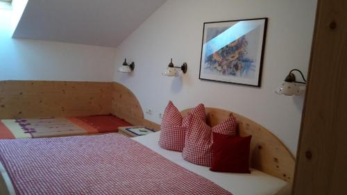 a bedroom with a bed with red and white pillows at Moarhof in Thurn