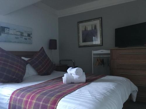 a hotel room with a teddy bear sitting on a bed at Urrard B&B in Dingwall