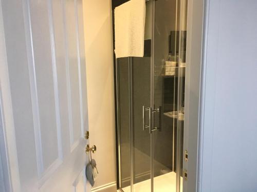 a shower with a glass door in a bathroom at Urrard B&B in Dingwall
