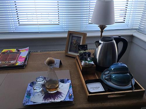 a table with a tea pot and a lamp on it at Urrard B&B in Dingwall