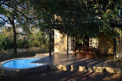 eine Terrasse mit einem Tisch und einem Stuhl auf einer Terrasse in der Unterkunft Kruger River Villas - Mtombo in Marloth Park