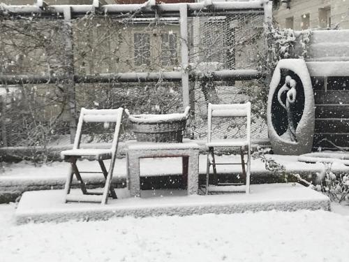 2 Stühle und ein Tisch im Schnee in der Unterkunft Hotel Valkenhof in Zoutelande