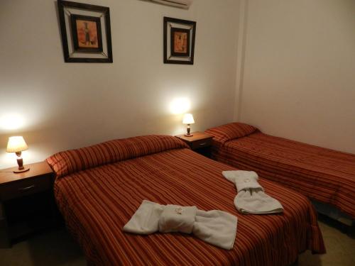 two beds in a hotel room with towels on them at Hotel Buenos Aires in Salta
