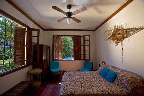 - une chambre avec un lit et un ventilateur de plafond dans l'établissement Casa Beleza, à Rio de Janeiro