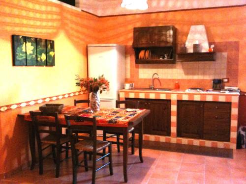 ファヴィニャーナにあるOrange House Favignanaのキッチン(テーブル、椅子、冷蔵庫付)