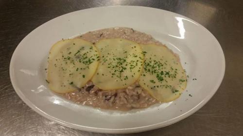 a plate of food with potatoes on top of meat at Hotel dell'Angelo in Predore