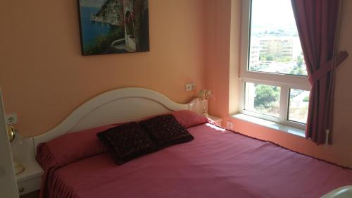 アルガロボ・コスタにあるRomantico Apartamento con Vistasのベッドルーム1室(紫色のベッド1台、窓2つ付)