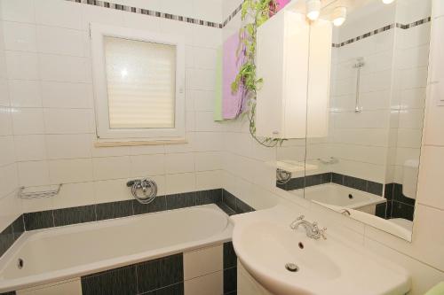 y baño blanco con lavabo y bañera. en Apartment Ivana, en Makarska