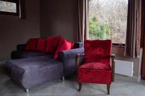 a living room with a couch and a chair and a window at Börzsöny Vendégház in Nagymaros