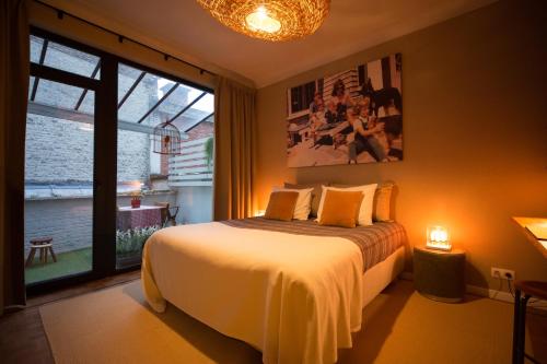 a bedroom with a bed and a large window at Aplace Antwerp boutique flats & hotel rooms in Antwerp