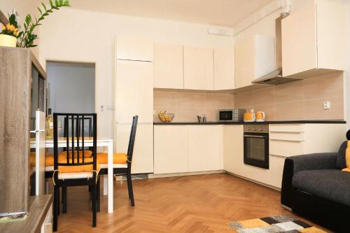 een keuken en een woonkamer met een tafel en een eetkamer bij Yellow apartment few steps from metro in Praag