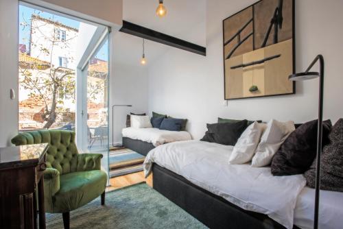 a bedroom with a bed and a couch and a chair at Portas De São Bento Apartments in Lisbon