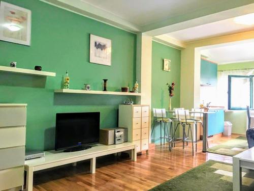 a living room with green walls and a flat screen tv at Apartment Vila Jezero in Zlatibor