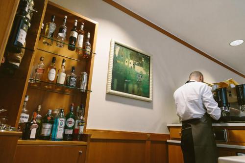 a man standing at a bar behind a counter at Hotel Residence Federiciano in Valenzano