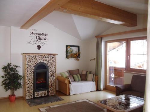 a living room with a fireplace and a couch at Ferienwohnung Hörbiger in Auffach