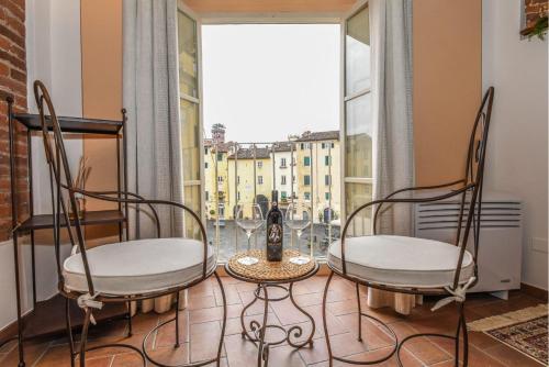 a room with two chairs and a table and a window at Micheli Suite Anfiteatro Square in Lucca