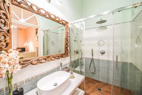 a bathroom with a sink and a shower and a mirror at Micheli Suite Anfiteatro Square in Lucca