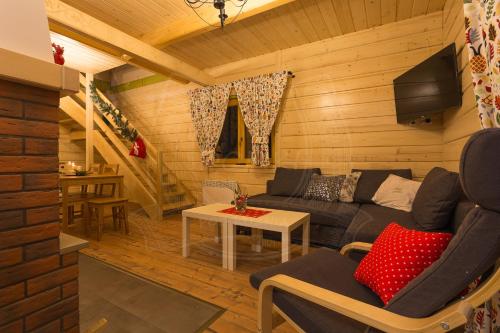 a living room with a couch and a table at Domki pod Kuźnią in Falsztyn