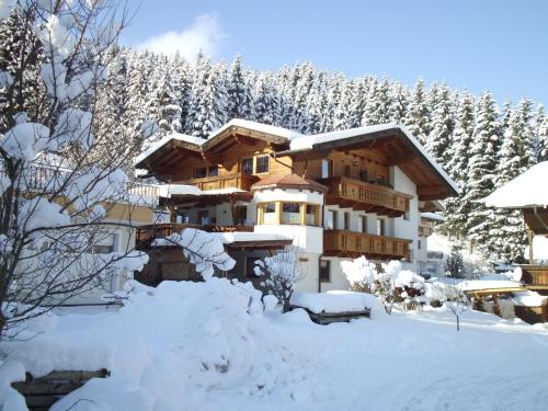 a lodge in the snow with snow covered trees at Ferienwohnung Hörbiger in Auffach