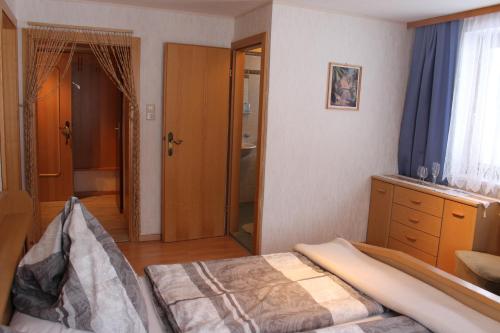 a bedroom with a bed and a bathroom with a window at Gästehaus Hanser in Virgen