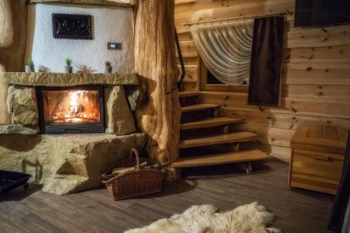 a living room with a fireplace in a log cabin at Domki u Bobaków in Ząb